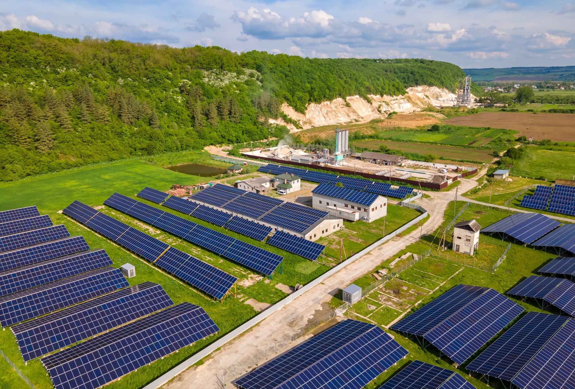 Aerial view of electrical power plant with rows of solar photovoltaic panels for producing clean